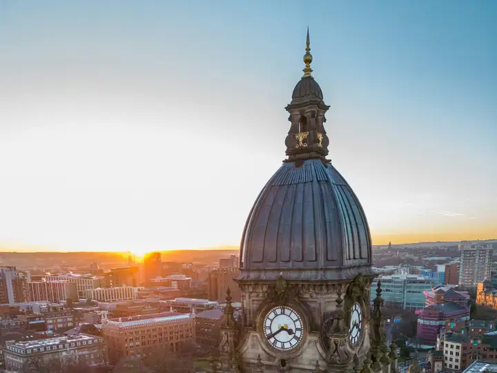 Leeds Town Hall clock tower above the city at sunset