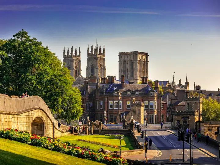 York Minster's towers above the city walls and flower beds on a sunny morning